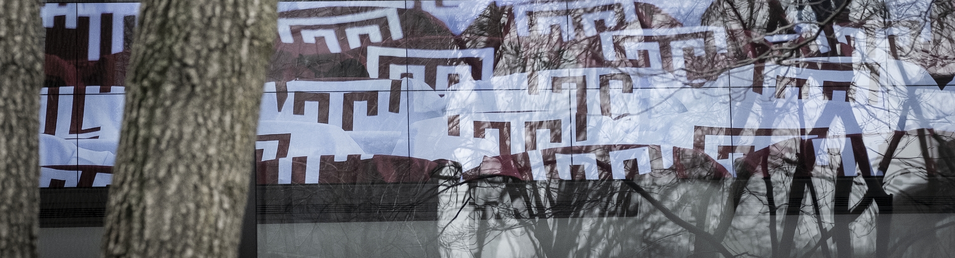 Temple University "T" logos reflected in a window.