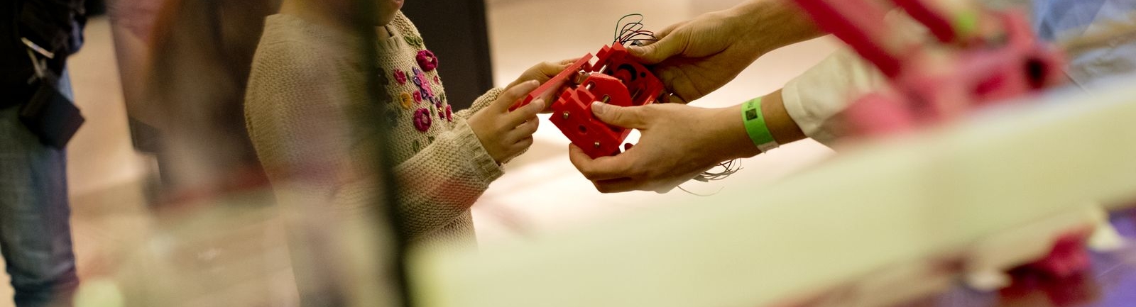 A Temple University professor shows a child a 3D-printed item.