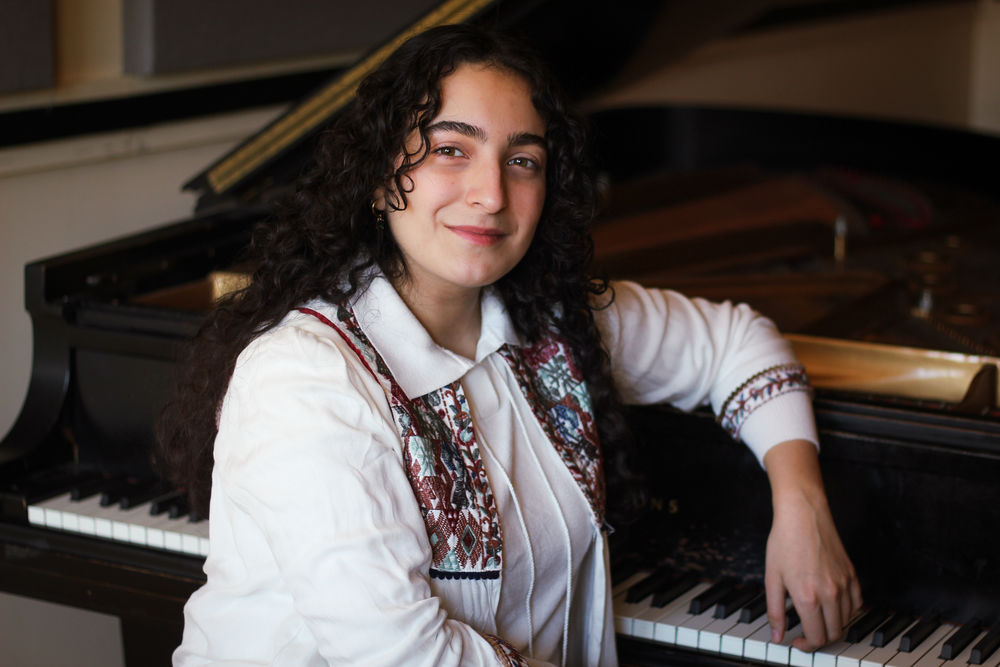 Negar Ghasemi posing with her piano 